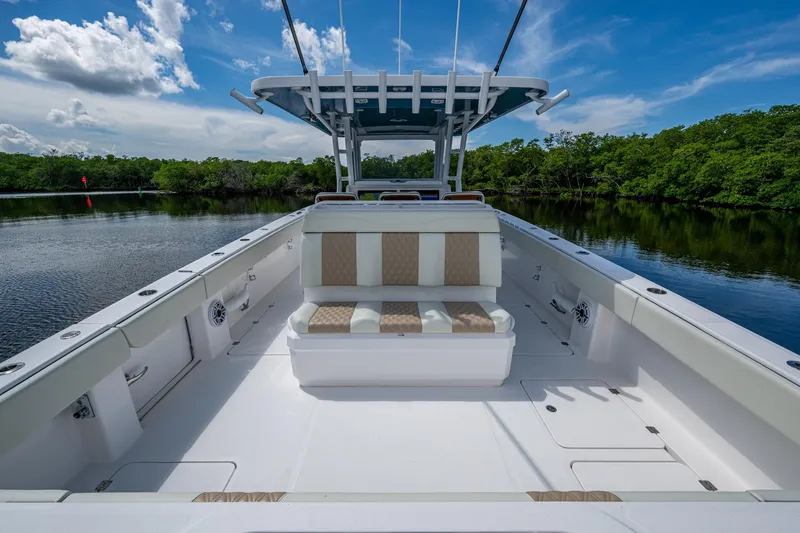 Slide: The Image of 2025 Invincible 37 Catamaran with spacious deck, sleek seating, and scenic water backdrop. - 13