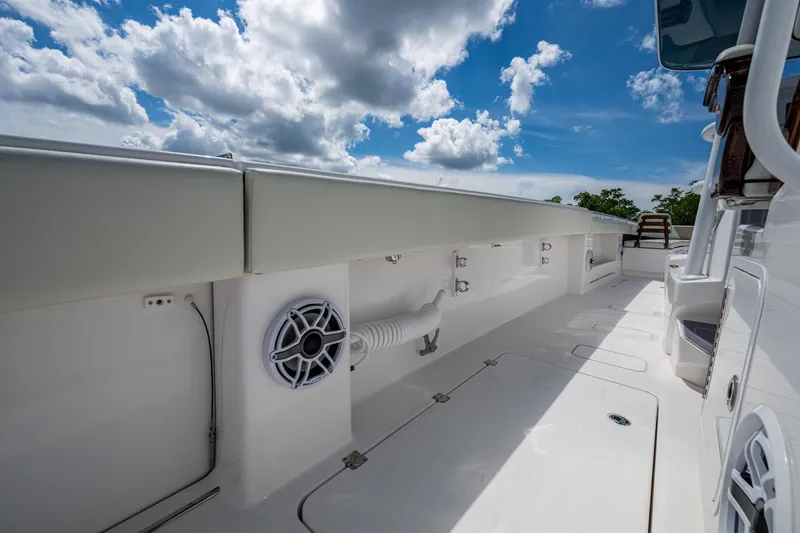 Slide: The Image of 2025 Invincible 37 Catamaran deck with speaker, under a partly cloudy sky. - 16