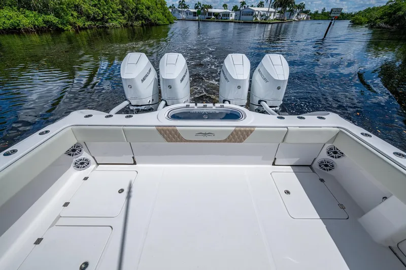 Slide: The Image of 2025 Invincible 37 Catamaran with quad Mercury engines on a serene waterway. - 19