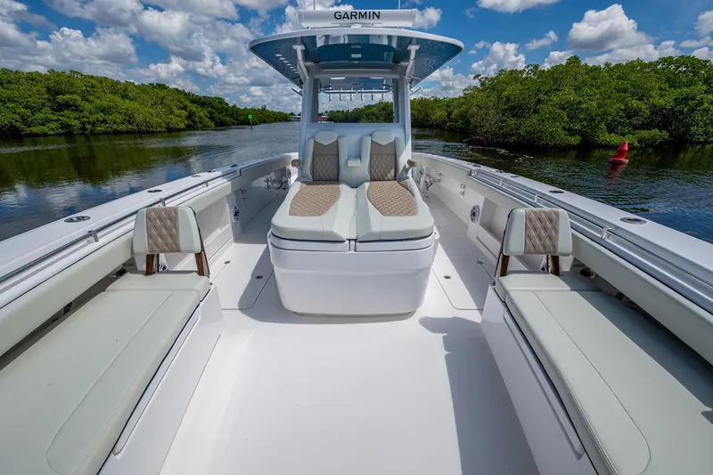 Slide: The Image of 2025 Invincible 37 Catamaran with luxurious seating, cruising on a scenic waterway. - 21