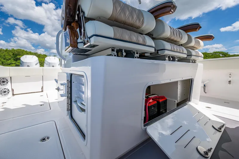 Slide: The Image of 2025 Invincible 37 Catamaran interior with storage compartment and seating, under a clear sky. - 9