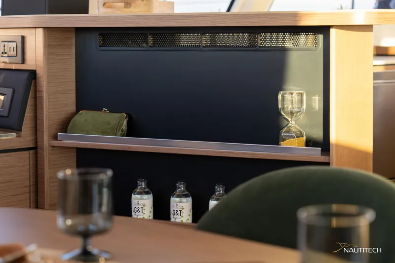 Slide: The Image of Interior of 2025 Nautitech 48 Open yacht with shelf, bottles, and hourglass. - 49