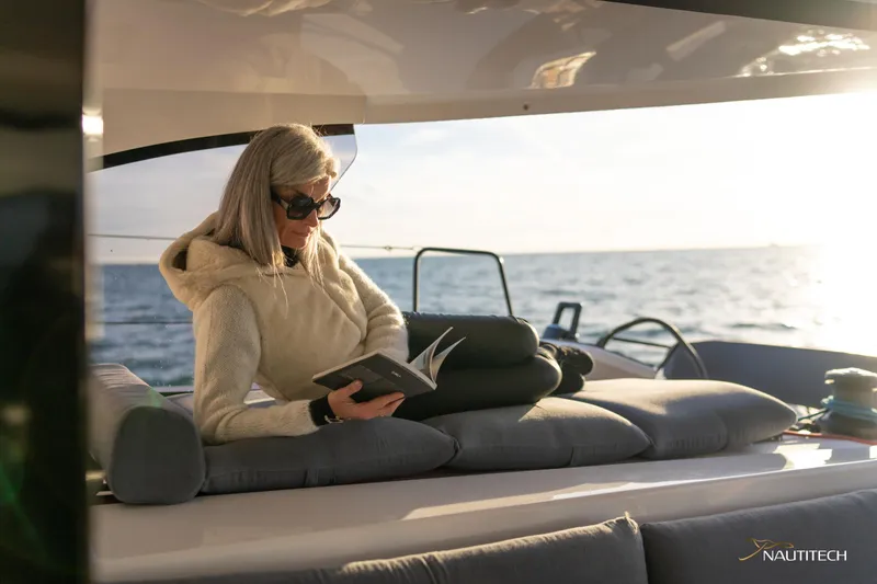 Slide: The Image of Woman reading on Nautitech 48 Open yacht, 2025 model, at sea. - 33
