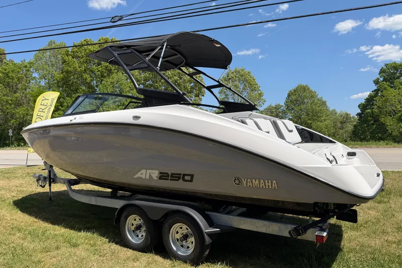 Slide: The Image of 2026 Yamaha AR250 boat on trailer, displayed outdoors with trees and blue sky. - 16