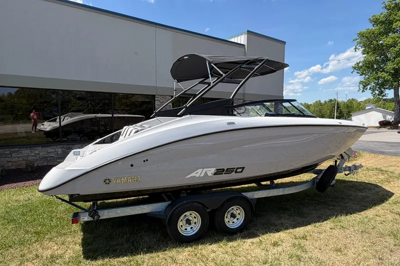 The Image of 2026 Yamaha AR250 boat on trailer, parked outdoors under clear blue sky. - 4