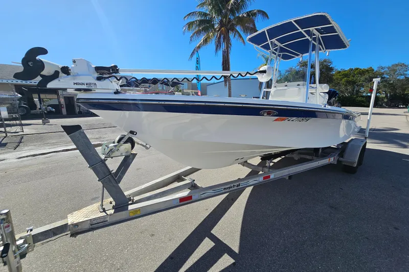 Slide: The Image of 2013 BlackJack 224 boat with Yamaha engine, parked outdoors under clear skies. - 13