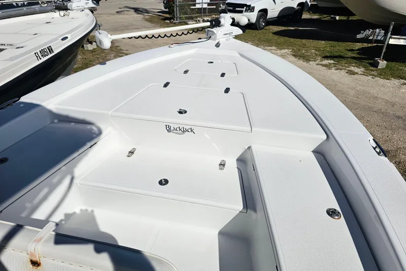 Slide: The Image of 2013 BlackJack 224 boat deck with storage compartments and clean white finish. - 16