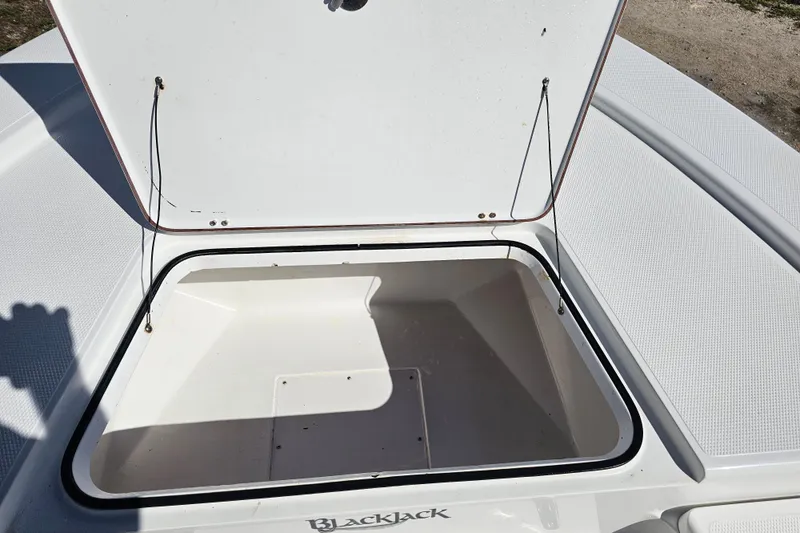Slide: The Image of Open storage compartment on a 2013 BlackJack 224 boat, showcasing interior space. - 17