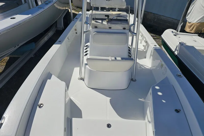 Slide: The Image of 2013 BlackJack 224 boat interior with seating and console, docked outdoors. - 21