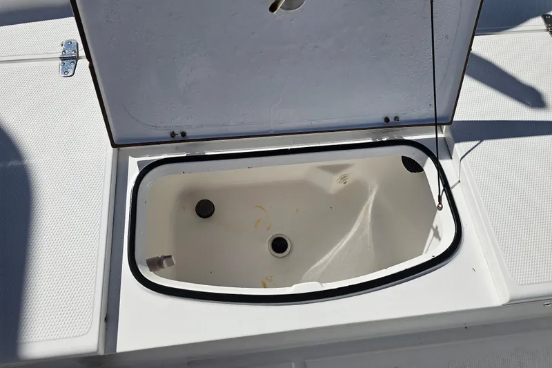 Slide: The Image of Open storage compartment on a 2013 BlackJack 224 boat, showing interior details. - 25