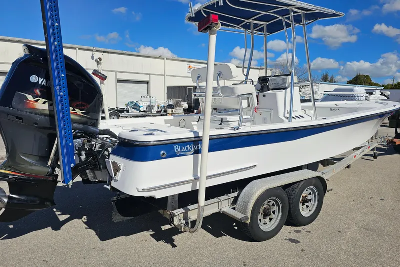 Slide: The Image of 2013 BlackJack 224 boat on trailer, featuring a sleek design and powerful outboard motor. - 4