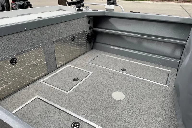Slide: The Image of 2024 Spartan 200 Astoria boat interior with storage compartments and diamond plate accents. - 14