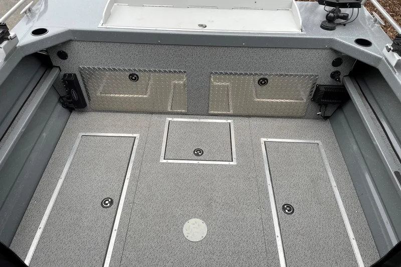 Slide: The Image of 2024 Spartan 200 Astoria boat interior with storage compartments and diamond plate accents. - 16
