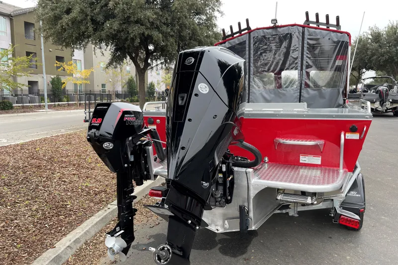 Slide: The Image of 2024 Spartan 200 Astoria boat with powerful outboard motors, parked on a street. - 17