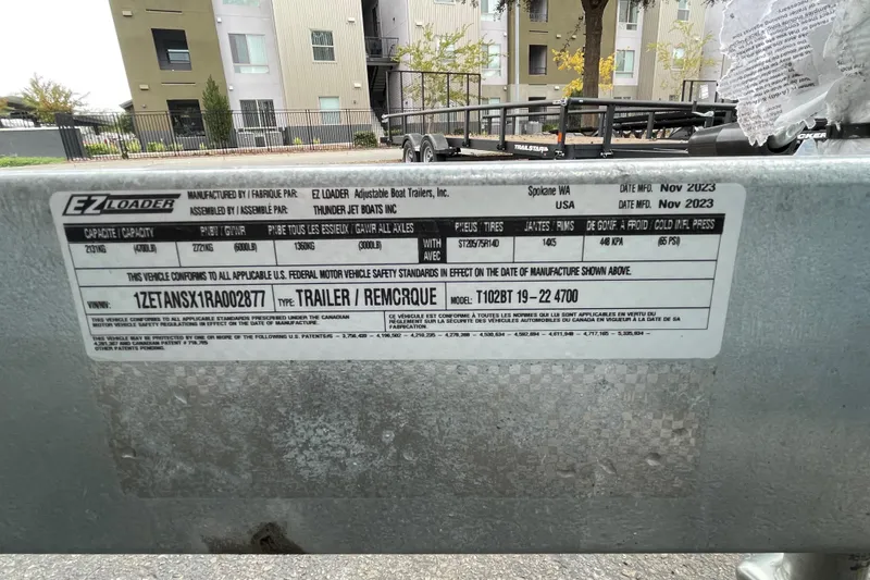 Slide: The Image of Label on EZ Loader trailer, manufactured November 2023, with specifications and compliance details. - 22