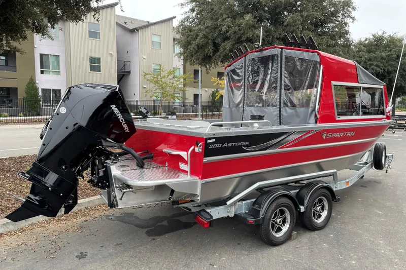 Slide: The Image of 2024 Spartan 200 Astoria boat, red and silver, on trailer with Mercury outboard motor. - 3