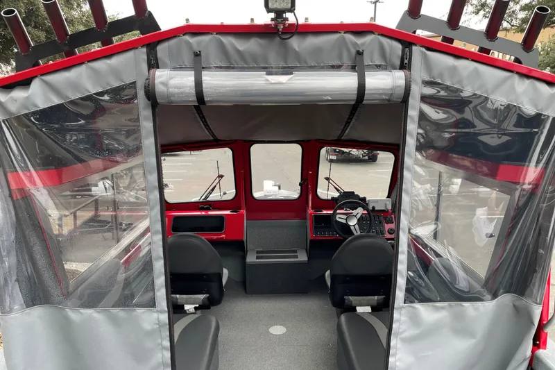 Slide: The Image of Interior view of 2024 Spartan 200 Astoria boat with steering console and seating. - 6