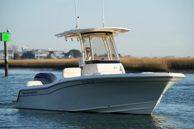 Slide: The Image of 2023 Grady-White Fisherman 216 boat cruising on calm waters near shoreline. - 17