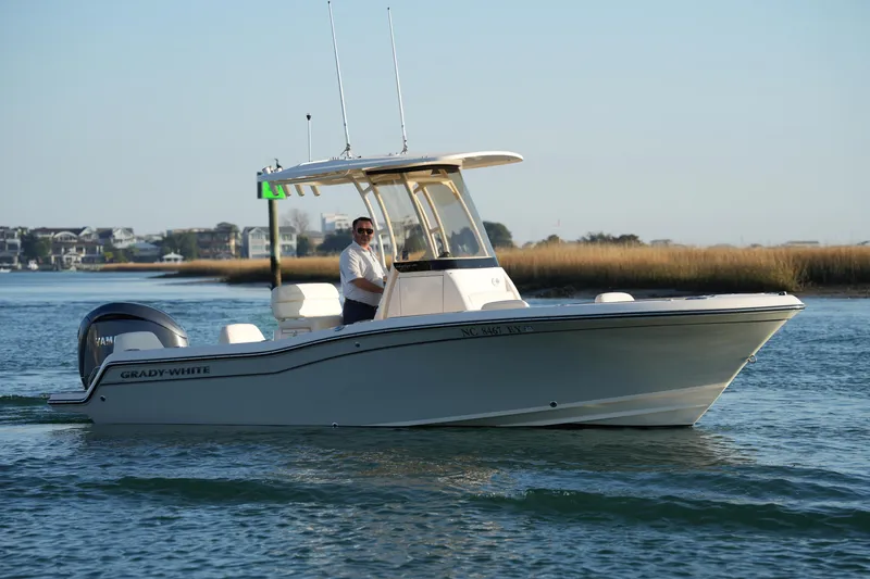 Slide: The Image of 2023 Grady-White Fisherman 216 boat cruising on calm waters near shoreline. - 19