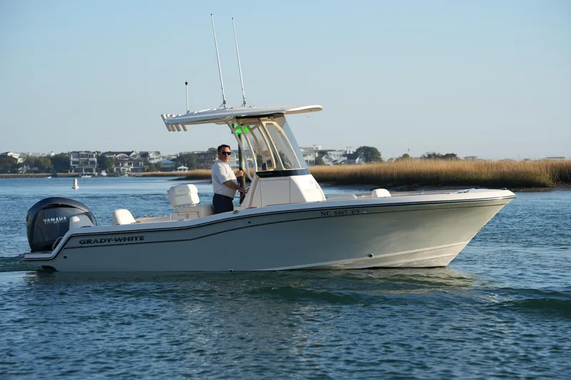 Slide: The Image of 2023 Grady-White Fisherman 216 boat cruising on calm waters near shoreline. - 20