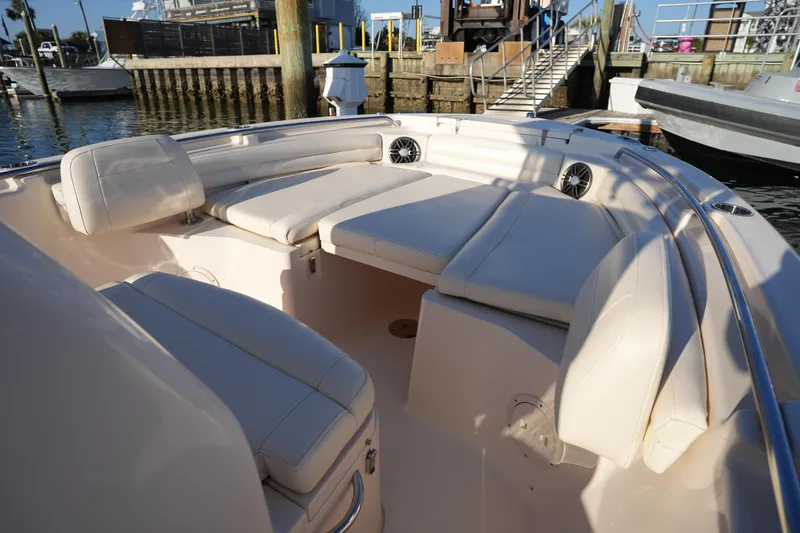 Slide: The Image of 2023 Grady-White Fisherman 216 boat interior with cushioned seating at a marina. - 40