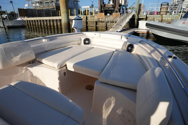 Slide: The Image of 2023 Grady-White Fisherman 216 boat interior with cushioned seating at a marina. - 43
