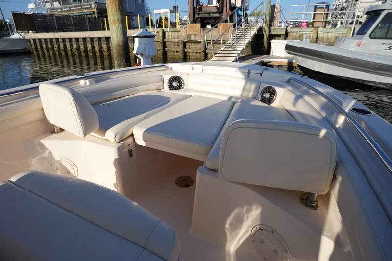 Slide: The Image of 2023 Grady-White Fisherman 216 boat interior with cushioned seating and speakers at a marina. - 44