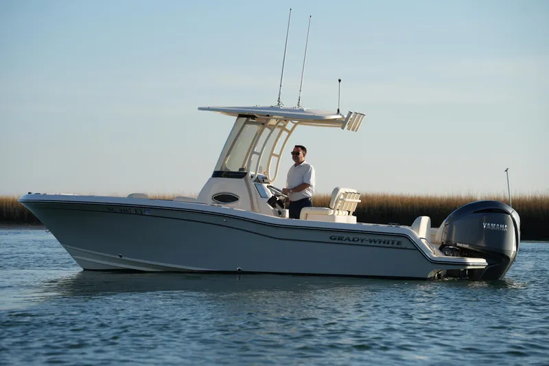 Slide: The Image of 2023 Grady-White Fisherman 216 boat on water, with person steering, clear sky background. - 9