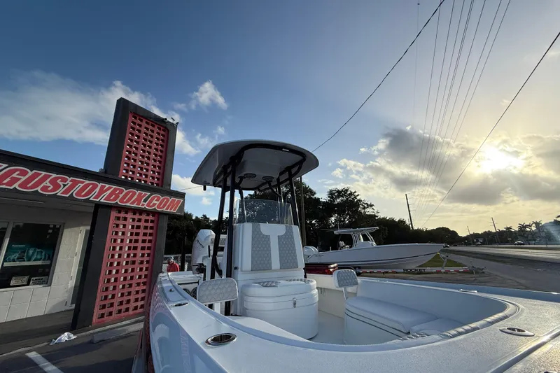 Slide: The Image of 2026 Contender 26 Bay boat's T-top with rod holders against cloudy sky. - 12