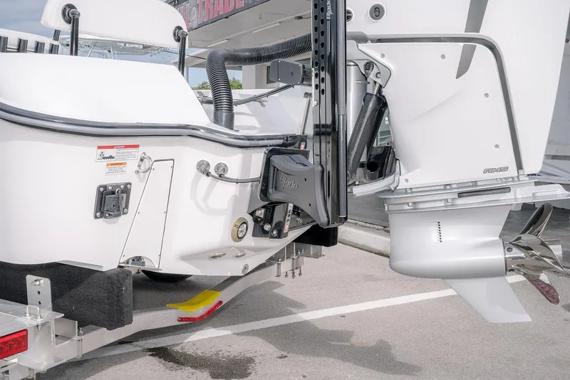 Slide: The Image of 2026 Contender 26 Bay boat with outboard motor and trailer, rear view. - 4