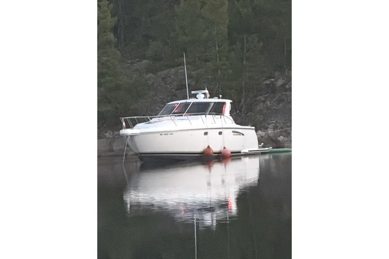 Slide: The Image of 2005 Tiara Yachts 3600 Sovran moored on calm water, surrounded by trees. - 10