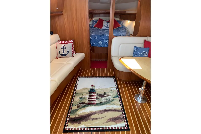 Slide: The Image of Interior of 2005 Tiara Yachts 3600 Sovran with nautical decor and lighthouse-themed rug. - 24