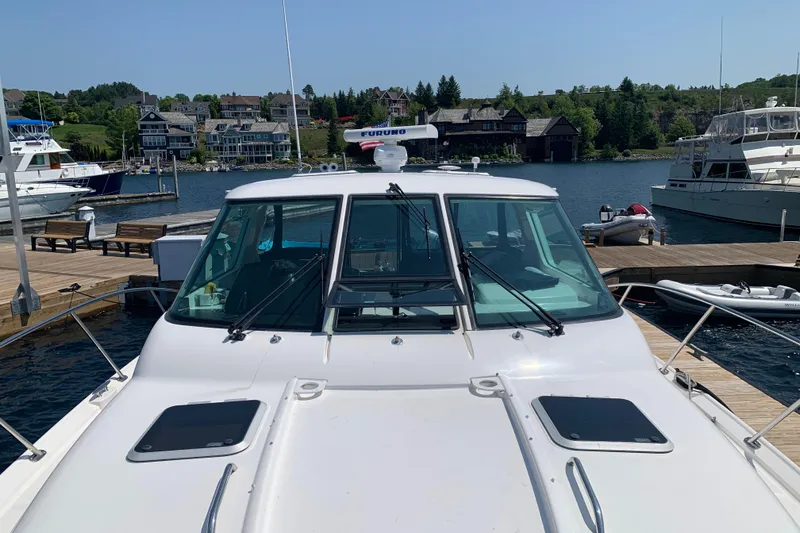 Slide: The Image of 2005 Tiara Yachts 3600 Sovran cruising on a sunny day near coastal homes. - 5