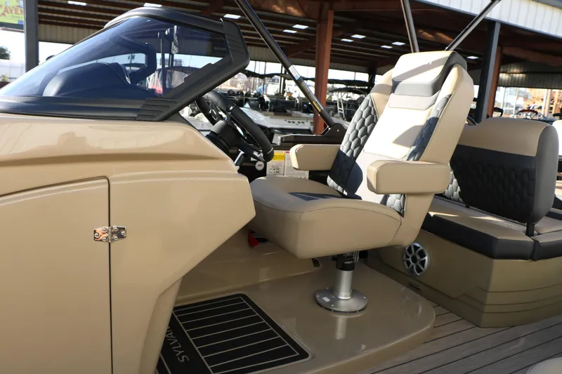 Slide: The Image of 2026 Sylvan L3 DLZ boat interior with beige captain's chair and steering console. - 23