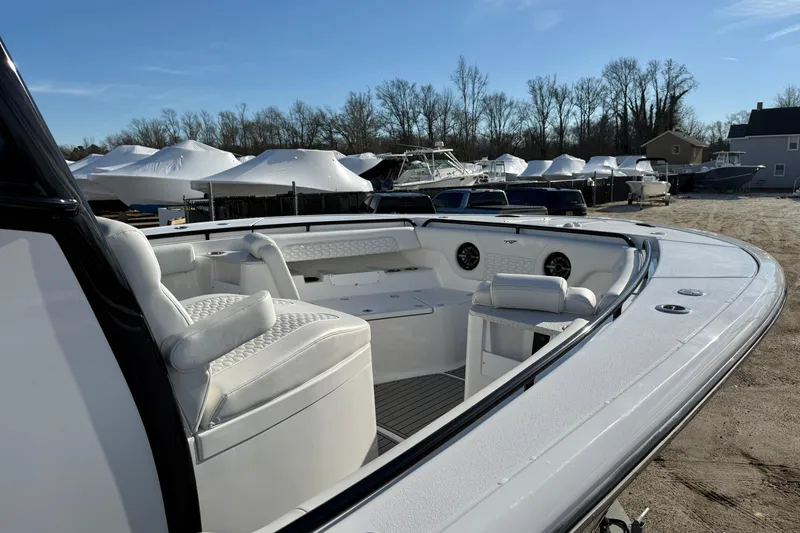 Slide: The Image of 2026 Tidewater 302 CC Adventure boat with white seating, docked outdoors. - 12