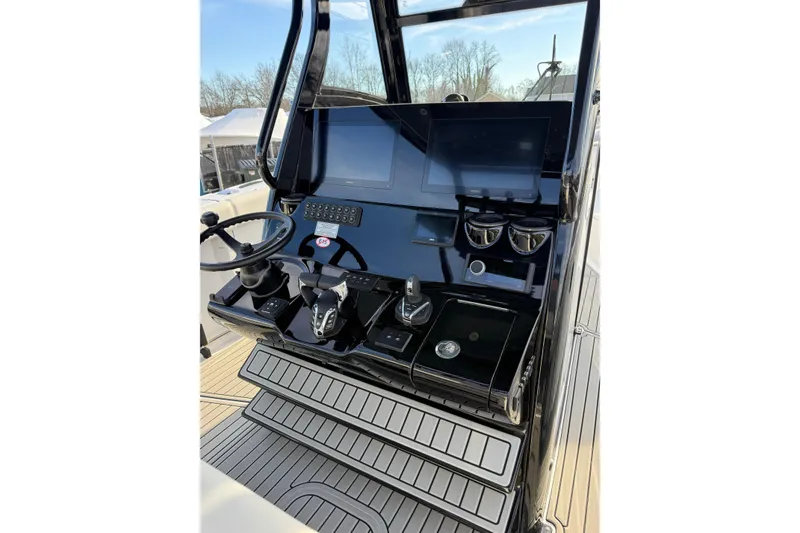 Slide: The Image of Helm of 2026 Tidewater 302 CC Adventure boat with modern controls and displays. - 24
