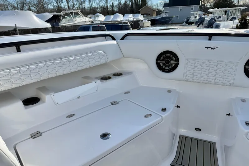 Slide: The Image of 2026 Tidewater 302 CC Adventure boat interior with white seating and speaker system. - 29