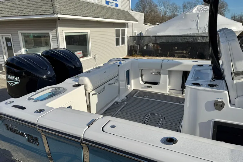 Slide: The Image of 2026 Tidewater 302 CC Adventure boat with dual Yamaha engines, docked near a marine shop. - 42
