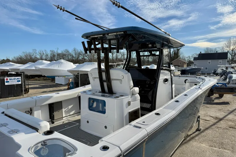 Slide: The Image of 2026 Tidewater 302 CC Adventure boat with fishing rods, docked under clear skies. - 43