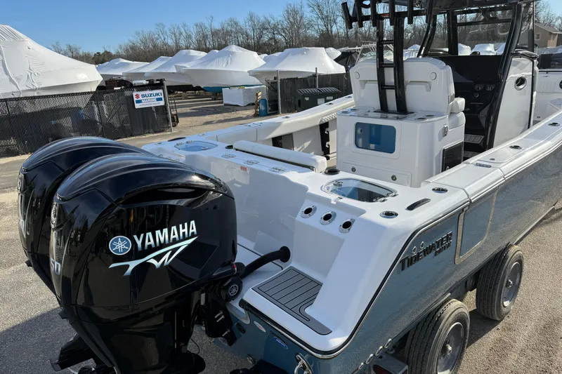 Slide: The Image of 2026 Tidewater 302 CC Adventure boat with dual Yamaha engines, parked outdoors. - 44