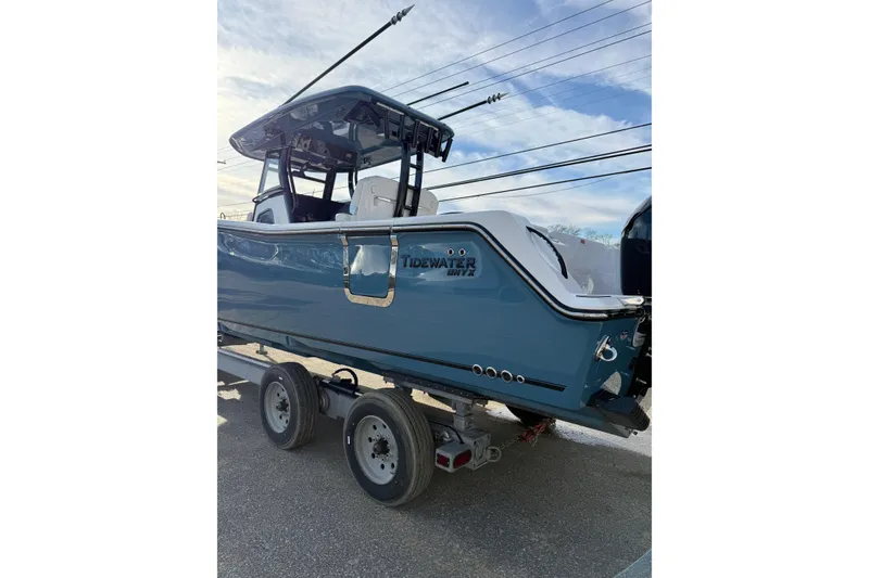 Slide: The Image of 2026 Tidewater 302 CC Adventure boat on trailer, blue hull, outdoor setting. - 46