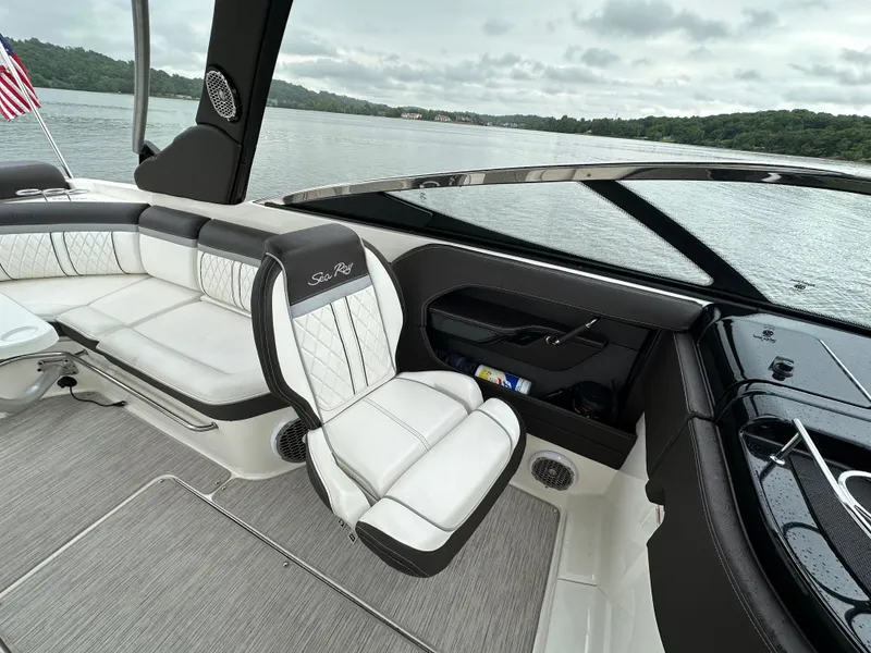 Slide: The Image of 2017 Sea Ray SLX 280 boat interior with white seating, on a calm lake. - 14