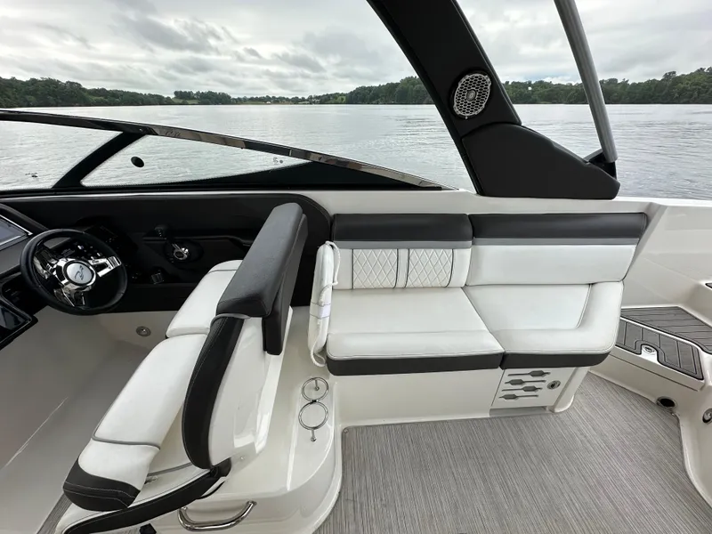 Slide: The Image of 2017 Sea Ray SLX 280 boat interior with sleek seating and modern design on a calm lake. - 16