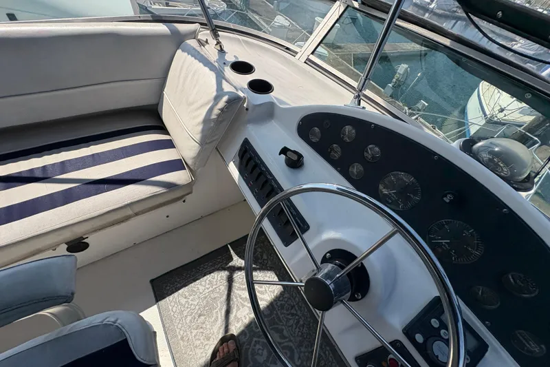 Slide: The Image of 1988 Bayliner 3587 Motoryacht helm with steering wheel and striped seating. - 38