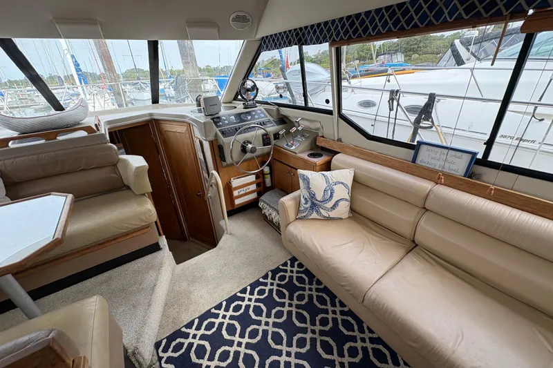 Slide: The Image of 1988 Bayliner 3587 Motoryacht interior with beige seating, nautical decor, and helm station. - 48
