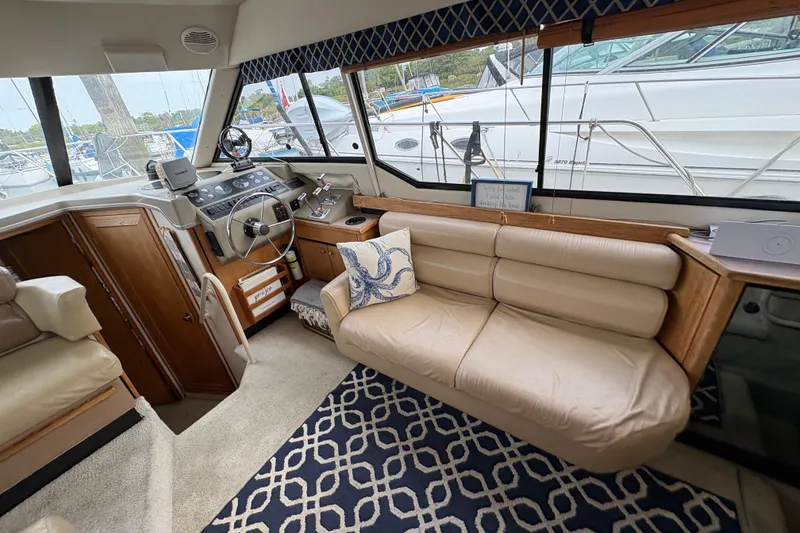 Slide: The Image of 1988 Bayliner 3587 Motoryacht interior with helm, beige seating, and nautical decor. - 49