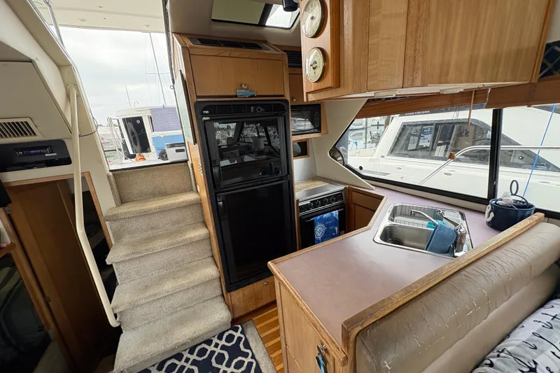 Slide: The Image of Interior of 1988 Bayliner 3587 Motoryacht with kitchen, stairs, and seating area. - 58