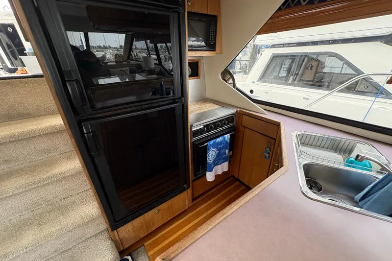 Slide: The Image of 1988 Bayliner 3587 Motoryacht kitchen with stove, sink, and refrigerator. - 60