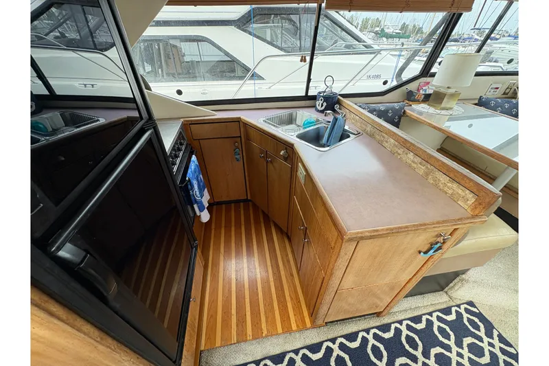 Slide: The Image of 1988 Bayliner 3587 Motoryacht interior kitchen with wood cabinetry and modern appliances. - 63