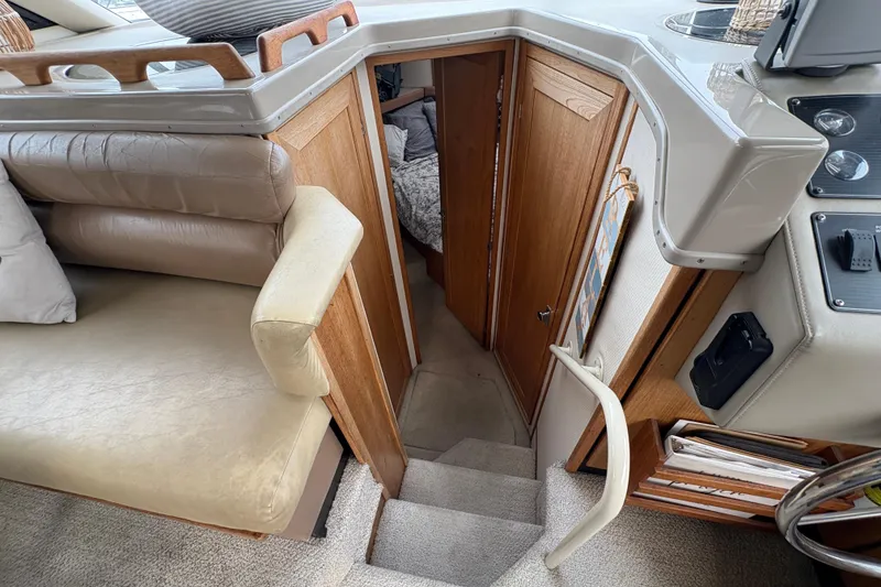Slide: The Image of 1988 Bayliner 3587 Motoryacht interior with stairs, beige seating, and wooden accents. - 69